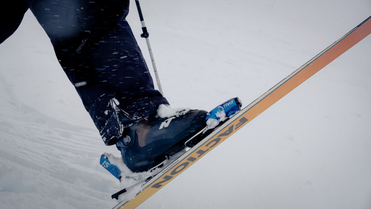 Detalle de una bota de ski calzada en su fijación sobre un ski Faction, con nieve fresca encima